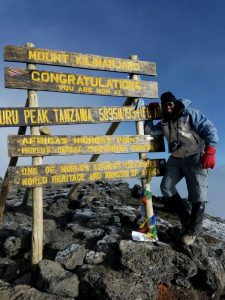 David Thuo Climbing Mt Kilimanjaro at Uhuru Peak